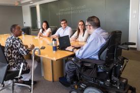 Group of 5 people with and without disabilities meeting around a table in the DC Citywide Conference Center