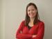 This is a headshot image of Alison Whyte. She is a white woman with poker straight brown hair. She has her arms crossed like a boss and is smiling.